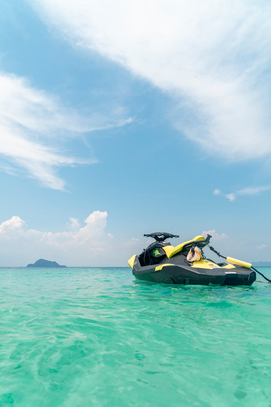 empty yellow and black jet ski in teal sea water